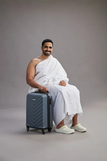 Saudi Man in Ihram Sitting with Travel Suitcase
