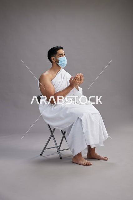 Saudi Man in Ihram Wearing Face Mask Praying in Studio