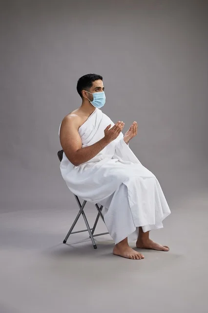 Saudi Man in Ihram Clothing Praying with Face Mask