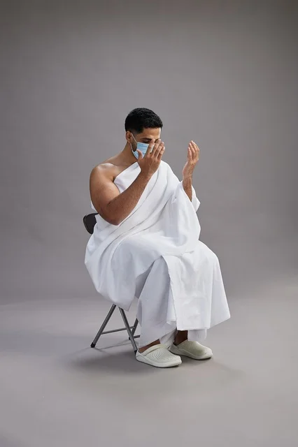 رجل سعودي بملابس الإحرام والكمامة يدعو