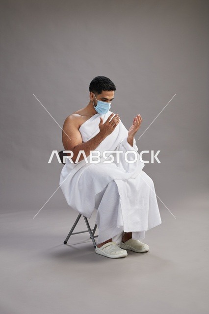 رجل سعودي بملابس الإحرام والكمامة يدعو