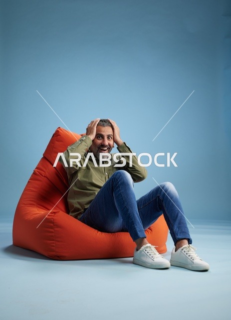 Surprised Middle Eastern Man on Beanbag Studio Shot