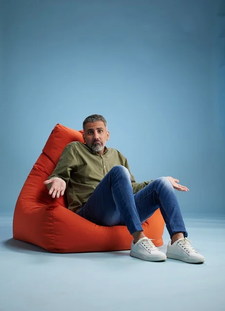 Confused Middle-Aged Man Sitting in Red Bean Bag Chair