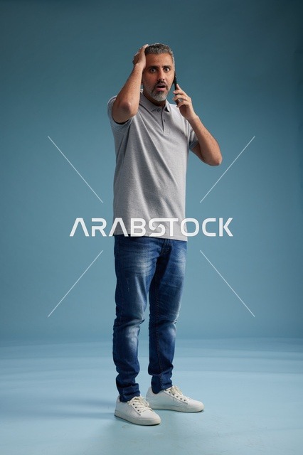 رجل سعودي يتحدث على الهاتف بتعبير وجه مصدوم