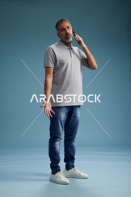 رجل سعودي يتحدث على الهاتف بتعبير وجه حائر