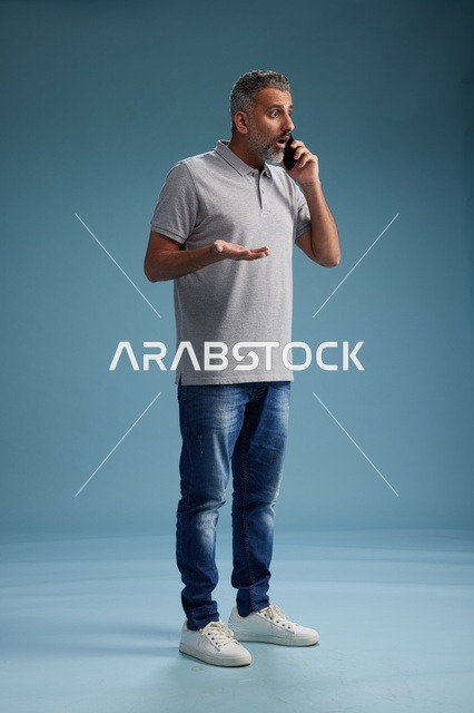رجل سعودي بملابس كاجوال يتحدث على الهاتف