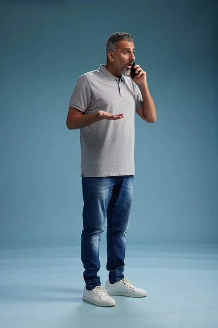 رجل سعودي بملابس كاجوال يتحدث على الهاتف