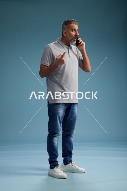 رجل سعودي يتحدث بالهاتف بملابس كاجوال