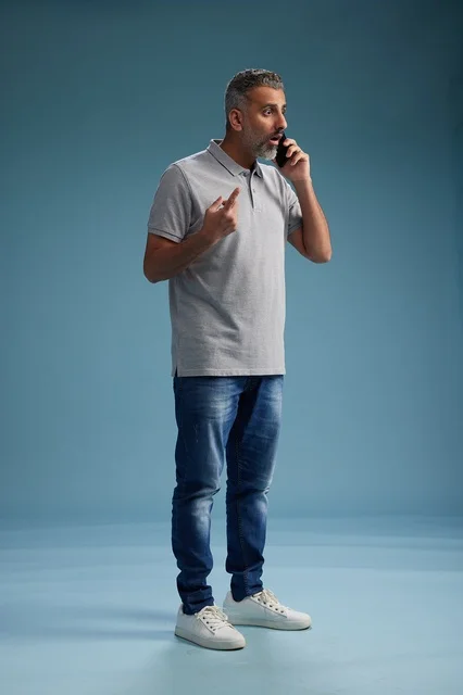 رجل سعودي يتحدث بالهاتف بملابس كاجوال