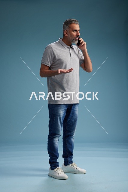 رجل سعودي بملابس كاجوال يتحدث بالهاتف المحمول