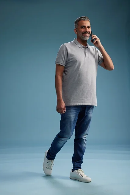 رجل سعودي بملابس كاجوال يتحدث عبر الهاتف في استوديو