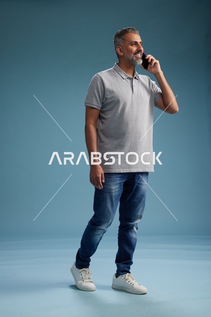 رجل سعودي بملابس كاجوال يتحدث على الهاتف