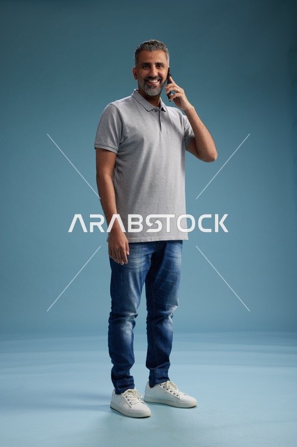 رجل سعودي بملابس كاجوال يتحدث على الهاتف الجوال
