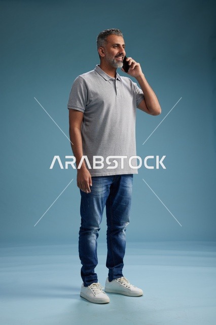 رجل سعودي يتحدث على الجوال بملابس كاجوال