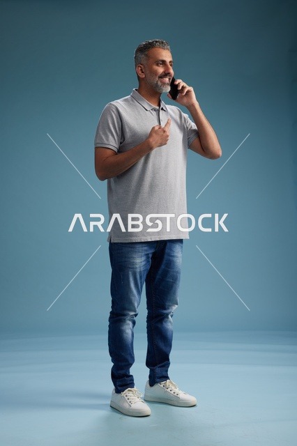 رجل سعودي بملابس كاجوال يتحدث عبر الهاتف الجوال