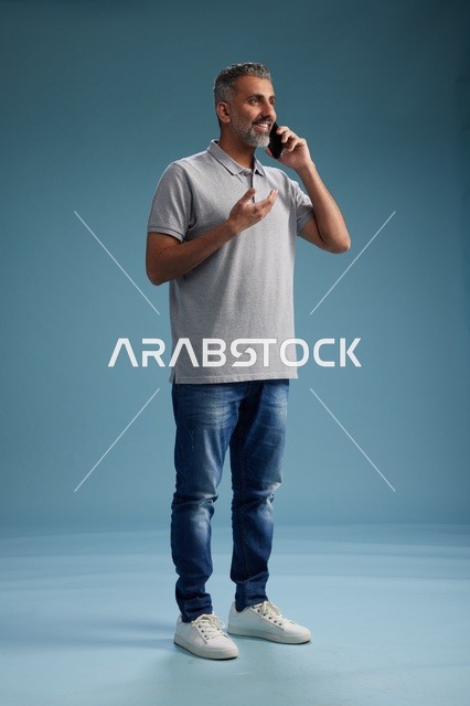رجل سعودي بملابس كاجوال يتحدث على الجوال