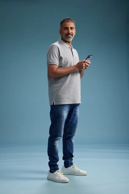 Middle-aged Arab Man with Smartphone on Blue Background