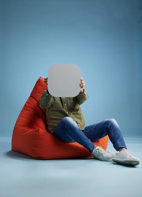 Saudi Man on Red Beanbag Holding Blank Sign