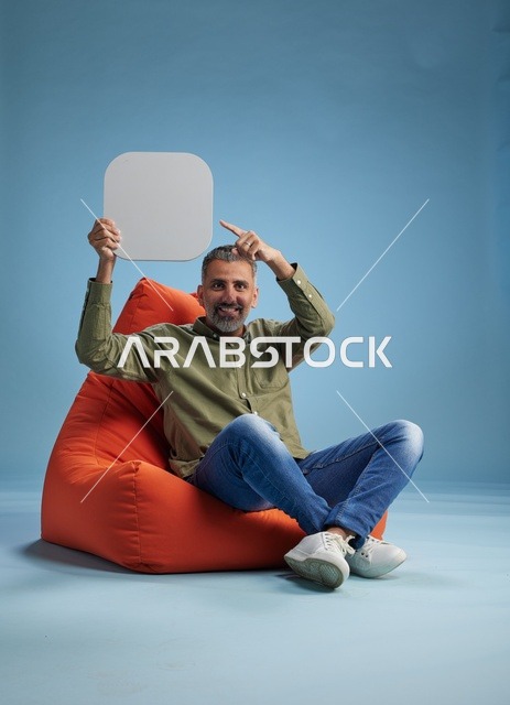 رجل سعودي بملابس كاجوال يحمل لافتة فارغة