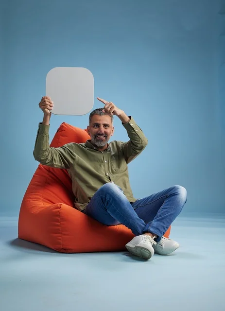 رجل سعودي بملابس كاجوال يحمل لافتة فارغة