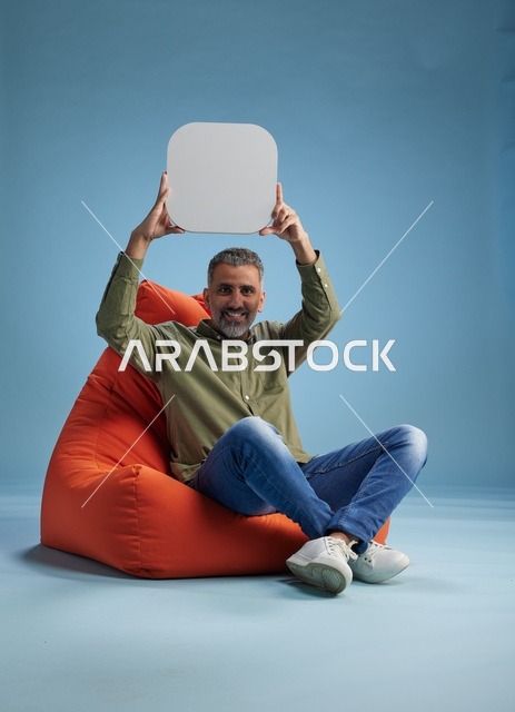 رجل سعودي يحمل لافتة فارغة في الاستوديو