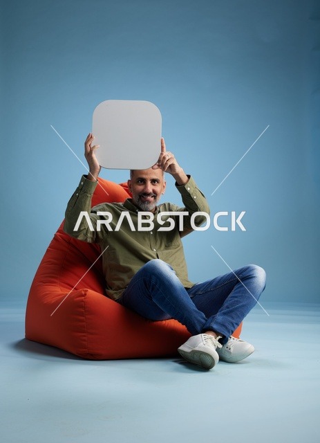 رجل سعودي يحمل لافتة فارغة على بين باج برتقالي