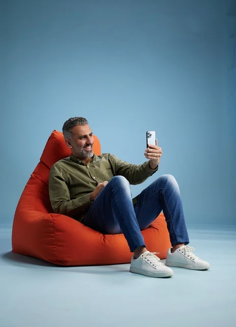 Saudi Man Using Smartphone on Bean Bag in Studio