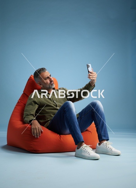 Saudi man taking a selfie or video call while relaxing