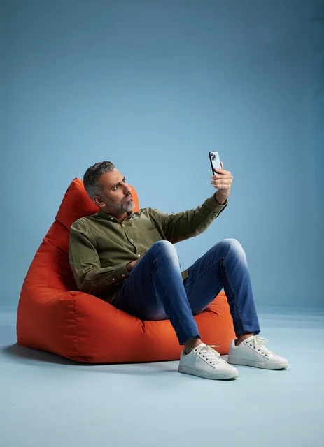 Saudi Man on Red Bean Bag Using Smartphone