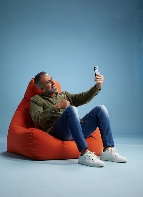 Saudi Man on Beanbag Taking Selfie in Studio