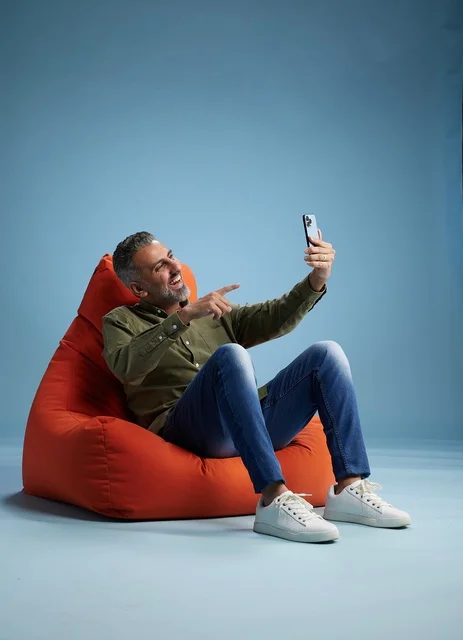 Saudi Man on Bean Bag Holding Smartphone Video Call