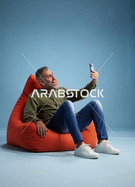 Saudi Man on Beanbag Using Smartphone Video Call