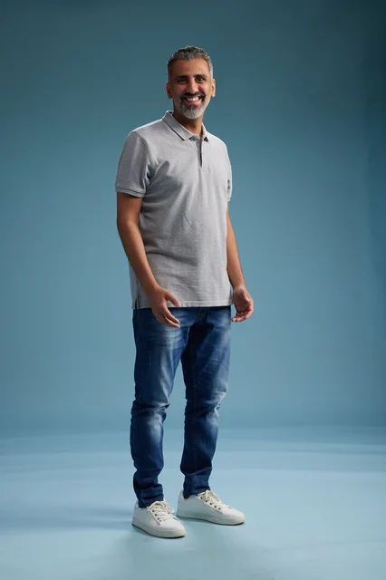 رجل سعودي بملابس كاجوال يقف في الاستوديو