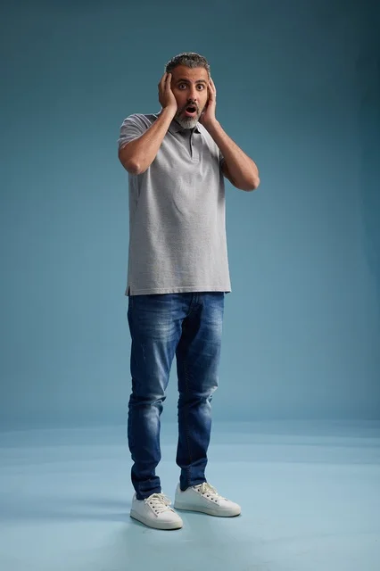 رجل سعودي مصدوم بملابس كاجوال خلفية زرقاء