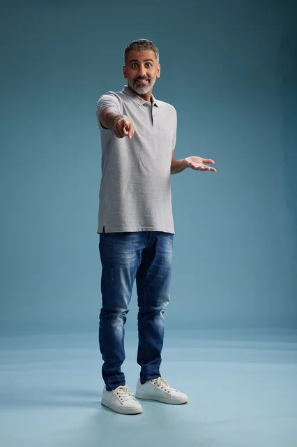 رجل سعودي بملابس كاجوال يشير للأمام في الاستوديو