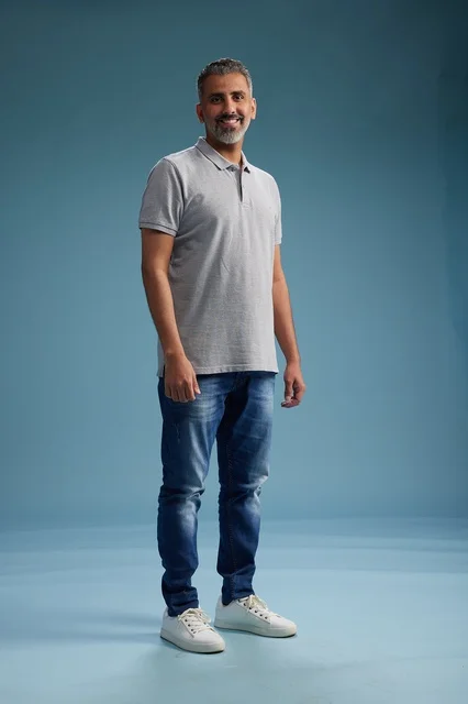 Saudi Man in Casual Polo Shirt Against Blue Background