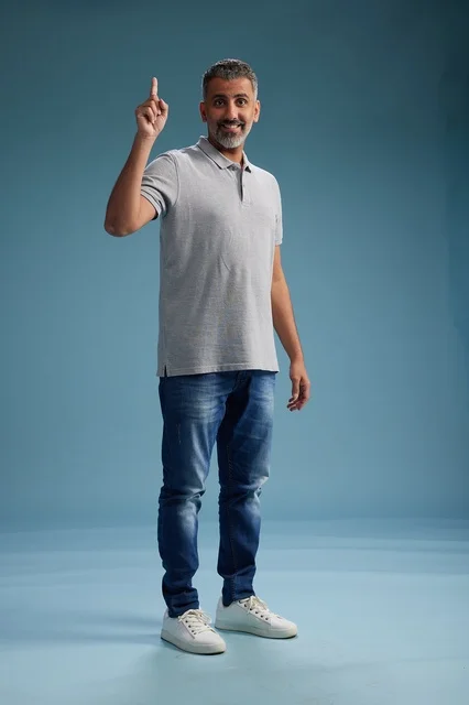 Saudi Man in Casual Clothes Pointing Up on Blue Background