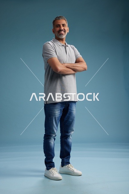 رجل سعودي بملابس كاجوال في استوديو بخلفية زرقاء