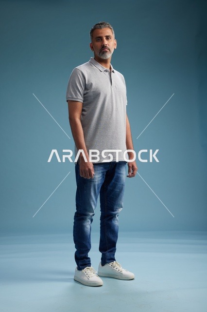 رجل سعودي بملابس كاجوال يقف في الاستوديو