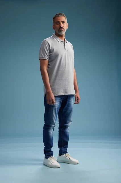 رجل سعودي بملابس كاجوال يقف في الاستوديو