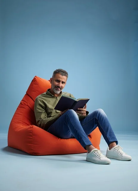 رجل سعودي يقرأ على كنبة كيس خلفية زرقاء