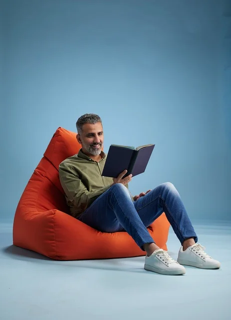 Saudi Man Reading Book on Orange Bean Bag Chair