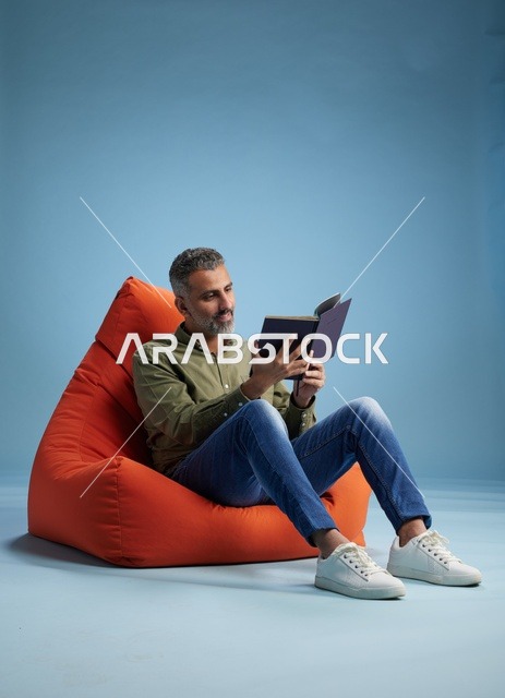 Saudi Man Reading a Book on Bean Bag Chair