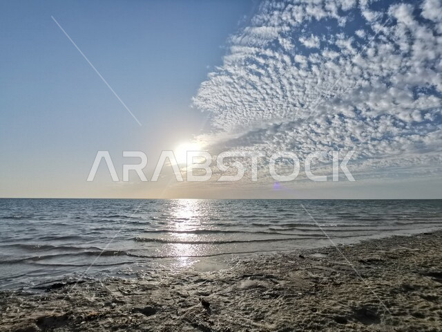 صورة للغيوم تغطي الشمس على شاطئ البحر في السعودية، منظر جمالي للغيوم في السماء على شاطئ البحر، مناظر طبيعية في المملكة العربية السعودية 