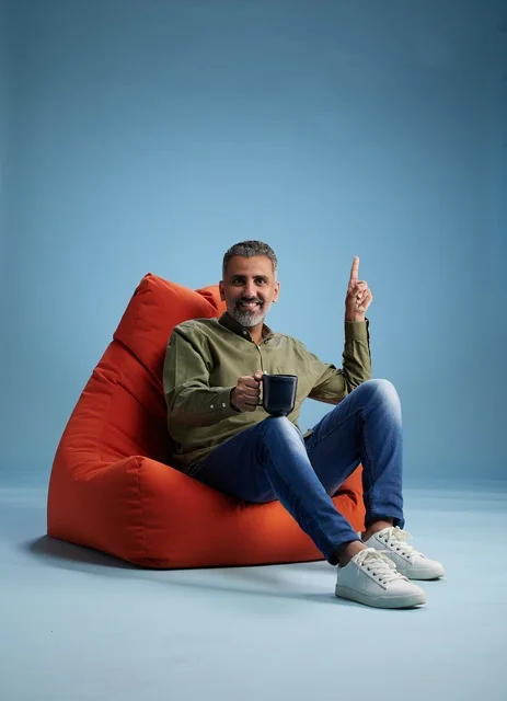 Saudi Man on Red Bean Bag Pointing Upward