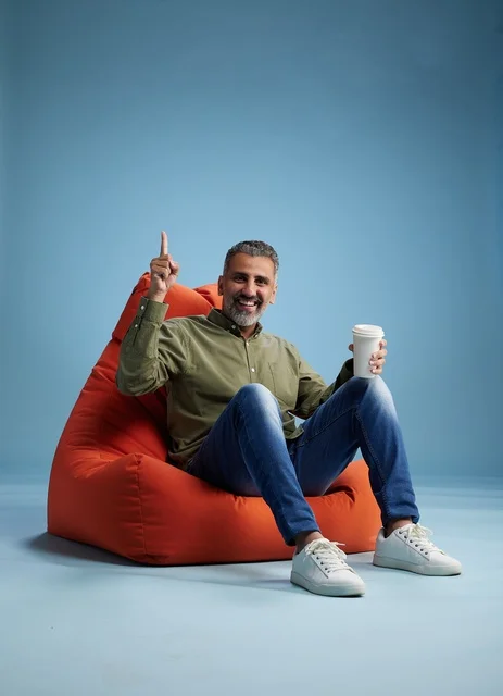 Saudi Man Relaxing on Bean Bag with Coffee Cup
