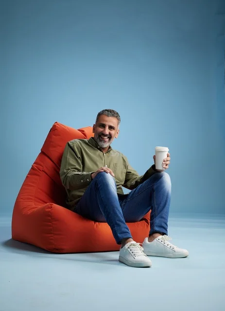 Saudi Man on Orange Bean Bag with Coffee in Studio