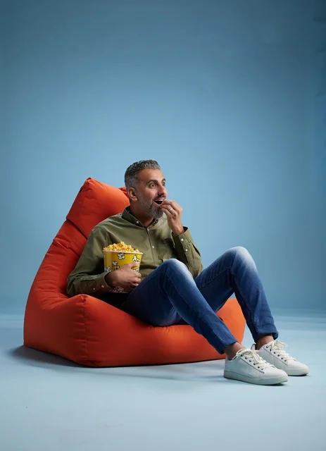 Saudi Man Eating Popcorn on Orange Bean Bag