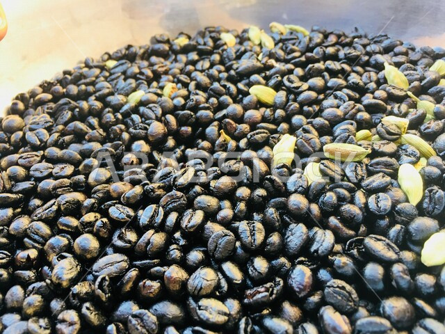 صورة مقربة لحبوب البن والهيل ، حبوب البن المحمصة،  مكونات القهوة العربية ،  اعداد مشروب القهوة اللذيذ 