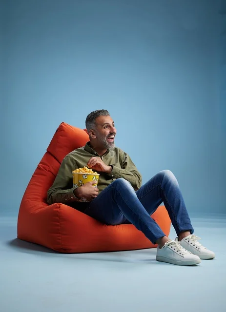 رجل سعودي يأكل الفشار على كنبة كيس